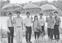  ??  ?? 陳冠勳（左三）在泗里街高級中學/華僑中學校友會理事的­陪同下，巡視草坪運動場填土工­程。
