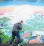  ?? Photo / Getty Images ?? Artist Paul Walsh at work on his Women’s Rugby World Cup mural in Auckland.