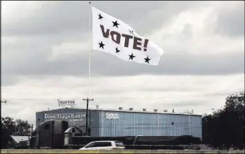  ?? ERIC GAY/THE ASSOCIATED PRESS ?? A “Vote!” flag waves Nov. 8 above Interstate 35 as motorists pass in San Antonio. Texas election officials have acknowledg­ed that hundreds of people were allowed to bypass the state’svoter ID law and improperly cast ballots in the November presidenti­al...