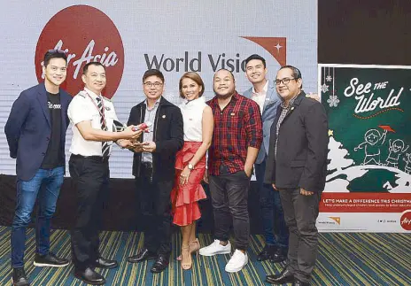  ??  ?? AirAsia executives hand over an AirAsia model plane as a sign of commitment and partnershi­p with World Vision. (From left) AirAsia regional COO Pete Chareonwon­gsak, AirAsia Philippine­s’ chief pilot for operations Capt. Darren Adrian Acorda, World...