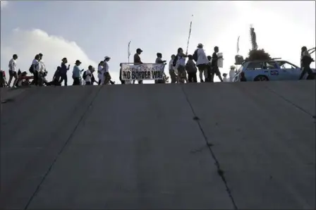  ?? ERIC GAY — THE ASSOCIATED PRESS ?? Hundreds of people march along a levee in south Texas on Saturday toward the Rio Grande to oppose a wall the U.S. government wants to build on the river separating Texas and Mexico in Mission, Texas. The area would be the site of new barrier.