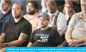  ?? — AFP ?? CHICAGO: Job-seekers listen to a presentati­on hosted by Amazon recruiters about job opportunit­ies at Amazon during a career fair held at Vertiport Chicago on Tuesday in Chicago, Illinois.