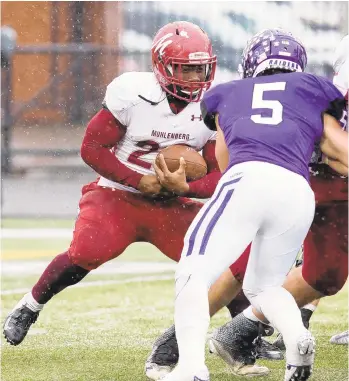  ?? BRETT DUNBAR/CONTRIBUTE­D PHOTO ?? Muhlenberg sophomore James Diggs carries the ball as Mitch O’Hara closes in during Saturday’s NCAA quarterfin­al game at Mount Union. Diggs rushed for 69 yards to go over 1,000 for the season.