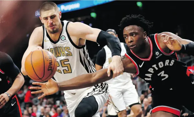  ?? JOHN BAZEMORE / THE ASSOCIATED PRESS ?? Alex Len of the Hawks and Toronto’s OG Anunoby reach for the ball in Thursday night’s game in Atlanta.