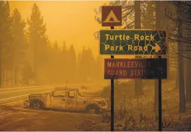  ?? Noah Berger / Associated Press ?? A scorched car sits on a roadside as the Tamarack Fire burns in the Markleevil­le community. Federal officials vowed to help the state fight fires.