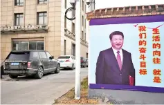  ??  ?? File photo of a roadside poster of Xi next to a hotel in Lankao in China’s central Henan province. — AFP photo