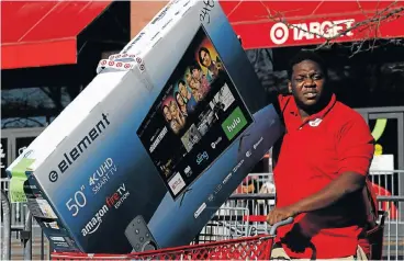  ?? /Reuters ?? Less frenzied: A man pushes a cartload of goods outside a Target store during Black Friday shopping in the Brooklyn borough of New York City, US. Stores also had carefully managed inventory.