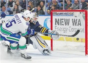  ??  ?? Canucks forward Derek Dorsett fires the puck past Sabres goalie Chad Johnson during the second period in Buffalo on Friday night.
