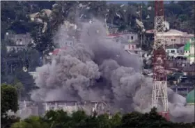  ?? AARON FAVILA — THE ASSOCIATED PRESS FILE ?? In this Friday file photo, debris and smoke rises after a Philippine Air Force fighter jets bombed suspected locations of Muslim militants, in Marawi city, southern Philippine­s. Southeast Asia’s jihadis who fought for the Islamic State in Iraq and Syria now have a different battle closer to home in southern Philippine­s. It’s a scenario raising significan­t alarm in Washington. The recent assault by IS-aligned fighters on the Philippine city of Marawi has left almost 300 people dead, exposing the shortcomin­gs of local security forces and the extremist group’s spreading reach.