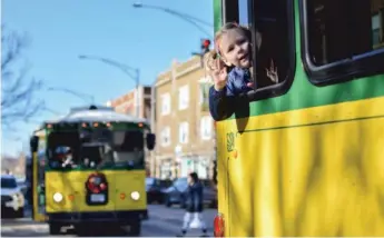  ?? ZACK MILLER/SUN-TIMES ?? Four-year-old Greta Bryant leans out the window of a trolley rented by the Greater Ravenswood Chamber of Commerce to bring people to local shops on Small Business Saturday.