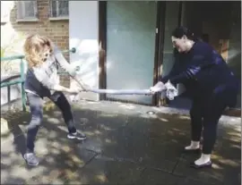  ??  ?? Jo Briggs (left) and Mireille Epstein wring out a towel used in the clean-up