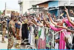  ??  ?? COTONOU, Benin: Benin soldiers look on as supporters wave to incumbent Benin President Patrice Talon on his arrival to vote at the Zongo Ehuzu polling station in Cotonou yesterday. —AFP