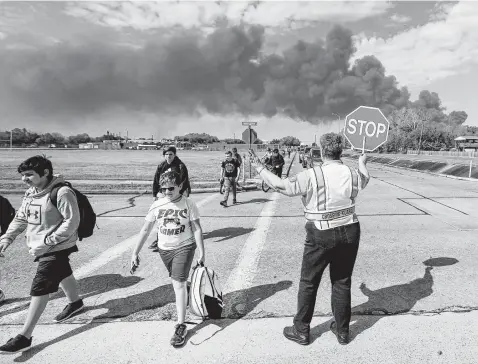  ?? Steve Gonzales / Staff photograph­er ?? Deer Park PD crossing guard Adell Boren makes sure Deer Park Junior High School students are safe as they cross East 13th and Meadowlark streets as a chemical fire burns nearby on March 19, 2019.