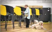  ?? Allen J. Schaben Los Angeles Times ?? A VOTER casts her ballot at a La Habra Heights polling location as her poodles wait on June 7.