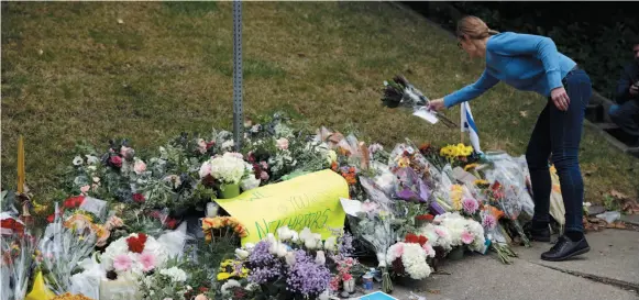  ?? AP PHOTO ?? A person brings flowers to a makeshift memorial at the Tree of Life Synagogue in Pittsburgh on Sunday.