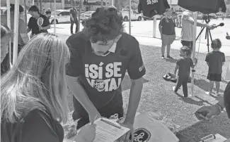 ?? PROVIDED BY JOSEPH GARCIA ?? Isai Barajas registers a new voter at a Water Days Event at Grant Park in Phoenix in July as part of the Sí Se Vota CPLC Action Fund voter engagement campaign.