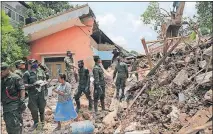  ?? JAYAWARDEN­A/THE ASSOCIATED PRESS] [ERANGA ?? Sri Lankan army rescuers remove debris from a house that was buried in the collapse of a garbage dump on the outskirts of Colombo. The rescuers were digging through heaps of mud and trash to search for survivors.
