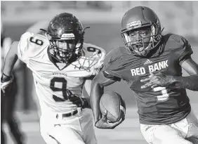  ?? STAFF PHOTO BY DOUG STRICKLAND ?? Red Bank’s Calvin Jackson runs past Walker Valley’s Dylan Towers during their prep football jamboree game Saturday at Finley Stadium. Jackson had two touchdown runs, including one for 66 yards, as the Lions beat the Mustangs 21-0.