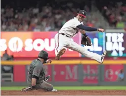  ?? USA TODAY SPORTS ?? The Braves’ Dansby Swanson avoids Diamondbac­ks baserunner Alex Avila on Friday night in Atlanta. The Diamondbac­ks won 2-1.