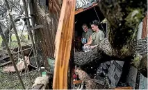  ?? PHOTO: WASHINGTON POST ?? Nahan Valdez, right, gathers supplies out of his destroyed home to take back to a shelter near City-by-the Sea, Texas.