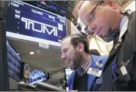  ?? REUTERS ?? Specialist trader gives the share price for Tumi Holdings Inc at the post where the stock is traded on the floor of the New York Stock Exchange.