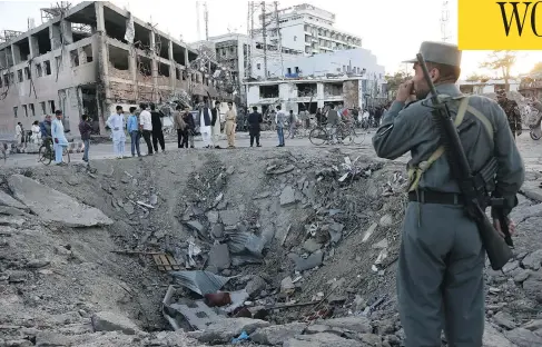  ?? RAHMAT GUL / THE ASSOCIATED PRESS ?? Security forces stand next to a crater created by a massive explosion in front of the German Embassy in Kabul, Afghanista­n, on Wednesday.