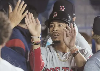  ?? AP PHOTO ?? FLYING NORTH: Mookie Betts gets high fives in the Red Sox dugout after scoring in last night’s 8-7 victory against the Blue Jays in Toronto; at right, Brian Johnson got the start in place of Eduardo Rodriguez and allowed four runs in five innings.