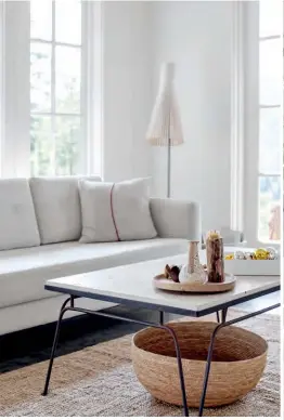  ??  ?? ABOVE Family ties define this earthy vignette: Finished with a new marble top, the metal coffee table frame hails from Carrie’s grandparen­ts’ farm, while her father-in-law made the wooden tray. FLOOR LAMP, LightForm; TOSS CUSHION, Provide.