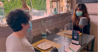  ?? ANSA ?? In pizzeria Un esempio di protezione con paretine in plexiglas per i clienti, al tavolo di un locale a Palermo
