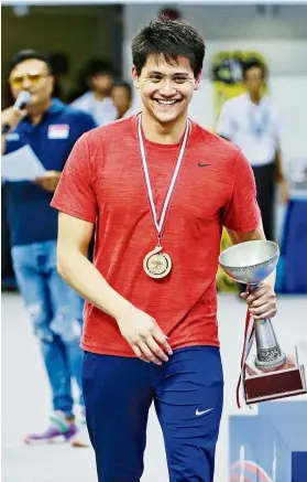  ??  ?? Joseph Schooling with the Chan Ah Kow Cup after winning the men’s 100m butterfly at the 14th Neo Garden Singapore National Swimming Championsh­ips on June 21.