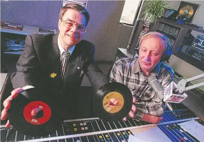  ?? SCOTT GARDNER THE HAMILTON SPECTATOR ?? CKOC program director Nevin Grant shows off some old 7" singles that the station still had even as the station became more dependent on computers alongside longtime disc jockey John Novak on April 3, 1997.