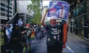  ?? KATHY WILLENS — THE ASSOCIATED PRESS ?? A Trump and gay rights supporter joins a group of people protesting discrimina­tion against Jewish people on Thursday in New York.