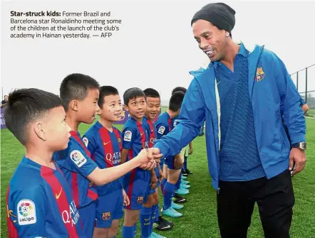  ??  ?? Star-struck kids: Former Brazil and Barcelona star Ronaldinho meeting some of the children at the launch of the club’s academy in Hainan yesterday.