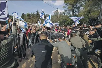  ?? Ahmad Gharabli AFP/Getty Images ?? A NEW Israeli law could jeopardize the citizenshi­p and residency status of Arabs convicted in attacks. Above, security forces reinforce barriers outside the Knesset, or parliament, in Jerusalem during a rally Monday.