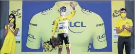  ?? FOTO: AP ?? Julian Alaphilipp­e flanqueado por una chica y un chico en el podio del Tour