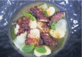  ??  ?? Galician-styled octopus with granja white beans and lardo in pork broth.