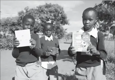  ?? PROVIDED TO CHINA DAILY ?? African children in Tanzania hold free anti-malaria brochures offered by Guilin Pharmaceut­ical Co Ltd on the World Malaria Day on April
25.