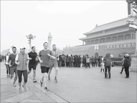  ?? Facebook ?? FACEBOOK CEO
Mark Zuckerberg leads a group of joggers through Beijing’s Tiananmen Square during a yellow- level smog alert.