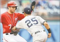  ?? Mitchell Layton / Getty Images ?? Gleyber Torres tags out Trea Turner of the Nationals on a pick-off at second base in the seventh inning of the first game of a doublehead­er Monday.