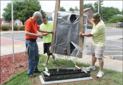  ?? The Sentinel-Record/Richard Rasmussen ?? PLACEMENT: From left, Dick Holden, Brandon Chrestman and Donald Newton guide the POW/MIA monument into place at the Garland County Veterans Memorial and Military Park on Tuesday.