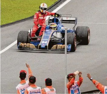  ?? Foto: afp ?? Nach seinem Unfall mit Lance Stroll nach dem Rennende musste Sebastian Vettel seinen Ferrari stehen lassen. Pascal Wehrlein nahm den roten Anhalter mit und chauffiert­e den Heppenheim­er.
