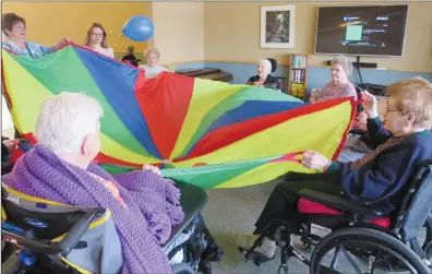  ?? NEWS PHOTO GILLIAN SLADE ?? You don’t have to be a kid to have fun and games. Residents at Valleyview seniors’ residence shake a large parachute and toss a balloon into the air in recreation therapy. Pictured are, clockwise from left, Mary Anne Janzen, recreation aide; Presley...