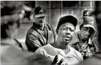  ??  ?? In 1987, Hank Aaron, Braves director of player developmen­t, talks with minor leaguers in West Palm Beach, Florida. After leaving that role, he spent the rest of his years in baseball as a Braves senior VP and assistant to the president. AJC 1987