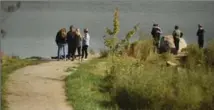  ?? DAVID BEBEE, RECORD STAFF ?? Friends and family comfort each other near the area of the Grand River where the body of Clayton Collison was found.