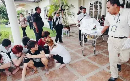  ??  ?? Bad landing: The woman who broke her leg being wheeled out of the bungalow by medical personnel in Kajang Country Heights yesterday.
