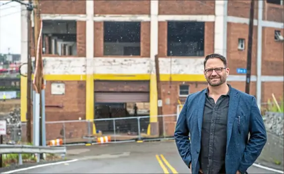  ?? Alexandra Wimley/Post-Gazette ?? Eric Booth, president of Desmone Architects, at the site of the future Brewers Block in the Strip District. The architectu­re firm also designed the recently completed Kaufmann’s Grand project, Downtown, that includes 311 apartments, two floors of retail, a parking garage and the 160-room Even Hotel.