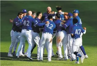 ?? BRYAN M. BENNETT GETTY IMAGES ?? The Blue Jays celebrated a walk-off two-run single to defeat the Orioles on Jackie Robinson Day last season, which was moved to from April 15 to Aug. 30 due to the COVID-19 pandemic.