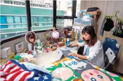  ??  ?? Jezz Ng siting at her desk where she rents a small living space in a co-sharing building in the Mong Kok district.