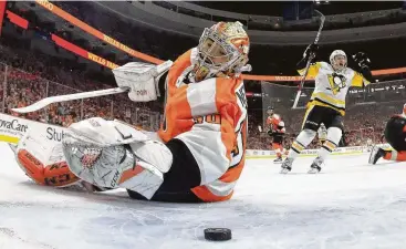  ?? Bruce Bennett / Getty Images ?? Sidney Crosby’s goal eludes Flyers goaltender Michal Neuvirth as Crosby’s Penguins teammate Jake Guentzel celebrates in the Game 6 win. Guentzel later celebrated his four-goal game.