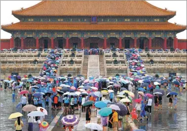 ?? LIU QIJIANG / FOR CHINA DAILY ?? Visitors hold umbrellas in front of the Hall of Supreme Harmony at the Palace Museum, also known as the Forbidden City, in Beijing on Tuesday. Heavy rainfall hit the capital and led to road collapses in the city’s suburbs.